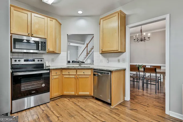 a kitchen with stainless steel appliances granite countertop a stove a sink and a microwave