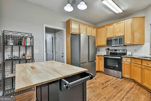 a kitchen with granite countertop stainless steel appliances and wooden cabinets