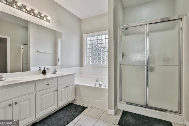 a bathroom with a tub a sink and mirrors