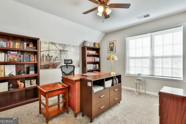 a view of a workspace with furniture and a bookshelf
