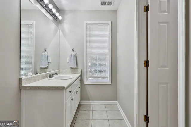 a spacious bathroom with a double vanity sink a mirror and a shower