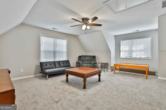 a living room with furniture and a air conditioner vent