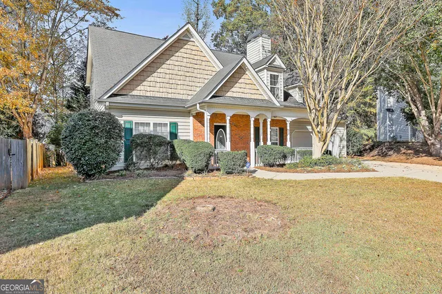 a front view of a house with a yard and trees