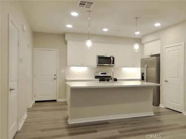 a kitchen with stainless steel appliances a refrigerator and a stove top oven