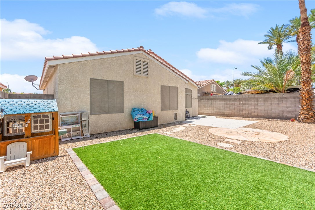 7353 Ridge Star Court Las Vegas, NV 89131 - Photo 34 of 36 A low-maintenance backyard oasis featuring synthetic turf and gravel, enclosed by a privacy wall.