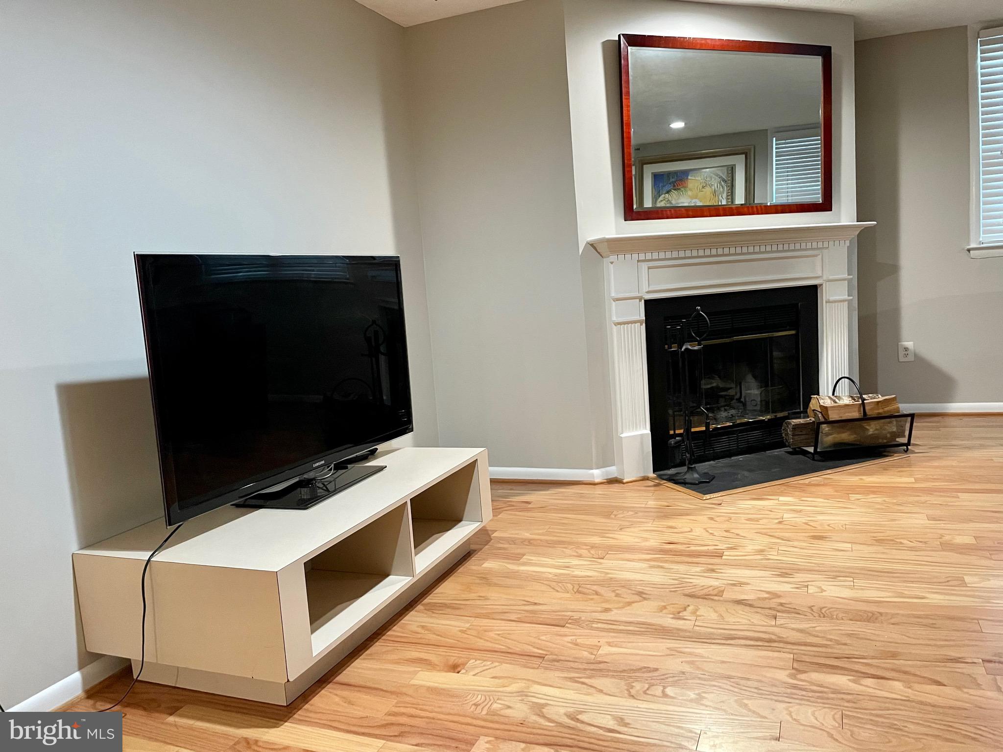 7 A Friendswood Court, Unit 7A Baltimore, MD 21209 - Photo 8 of 32 a living room with a fireplace and a flat screen tv