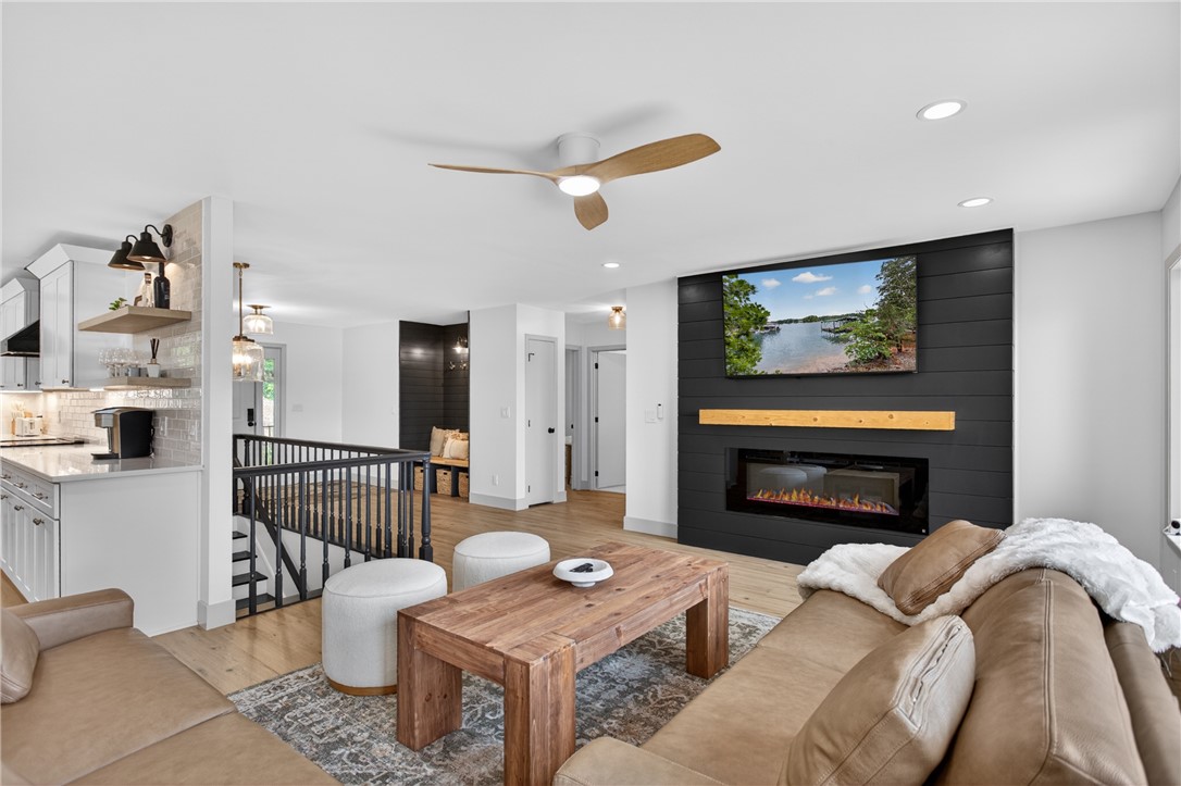304 Lakeside Drive Seneca, SC 29672 - Photo 6 of 50 A well-lit, open-concept living space with a modern fireplace feature and direct kitchen access.