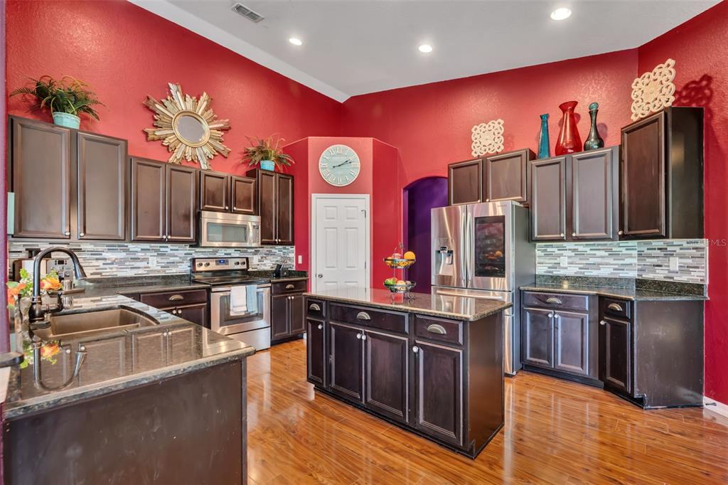 4946 Northeast 124th Road Oxford, FL 34484 - Photo 18 of 69 a kitchen with stainless steel appliances granite countertop a stove a sink dishwasher and a refrigerator
