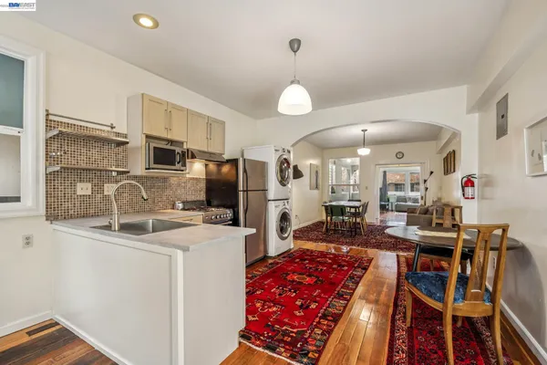 a kitchen that has a lot of cabinets a sink and appliances