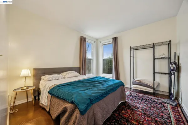 a bedroom with a bed and a lamp with wooden floor