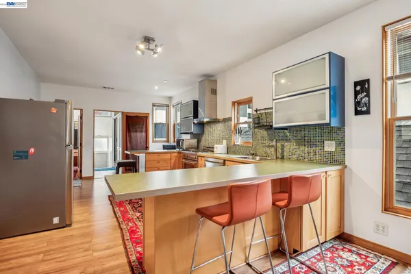 a kitchen with stainless steel appliances granite countertop a refrigerator a sink a stove and white cabinets