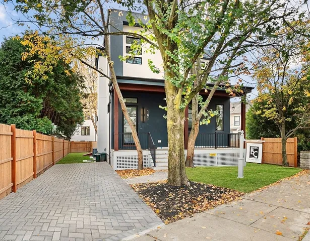 a view of a brick house with a large windows and a tree