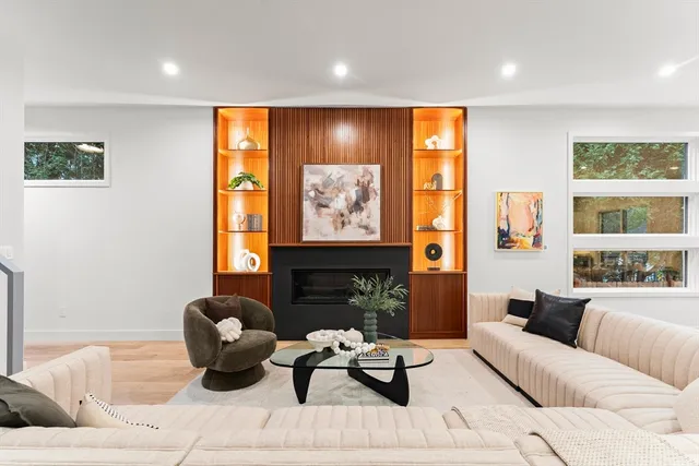 a living room with fireplace furniture and a large window