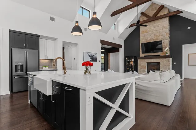 a kitchen with stainless steel appliances kitchen island granite countertop a stove a sink and a refrigerator