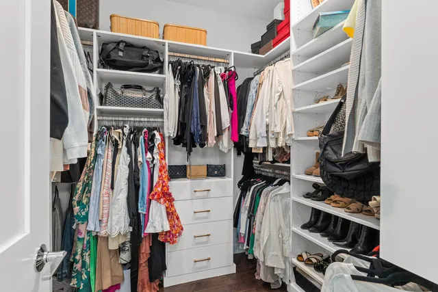 a view of walk in closet with clothes
