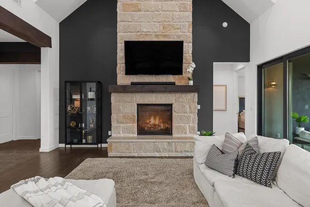 a living room with furniture a flat screen tv and a fireplace