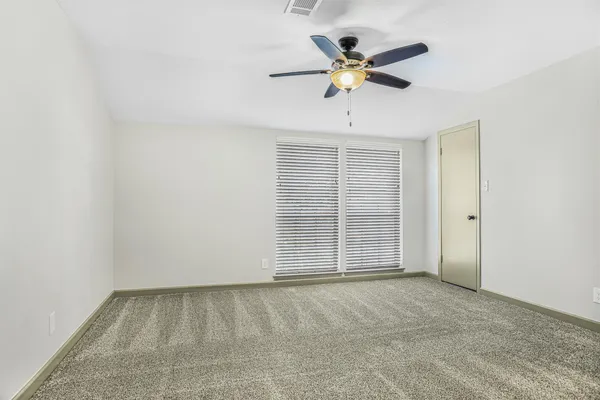 an empty room with closet and fan