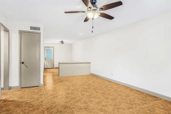 an empty room with closet and a ceiling fan