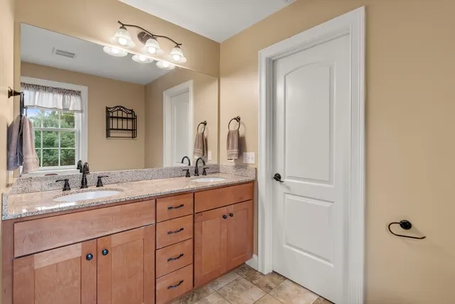a bathroom with double sink and a mirror