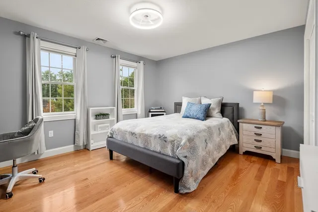 a bedroom with a bed and wooden floor