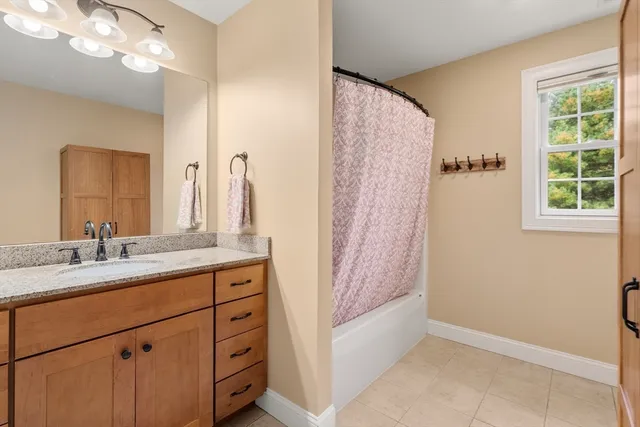 a bathroom with a granite countertop sink a mirror and a shower