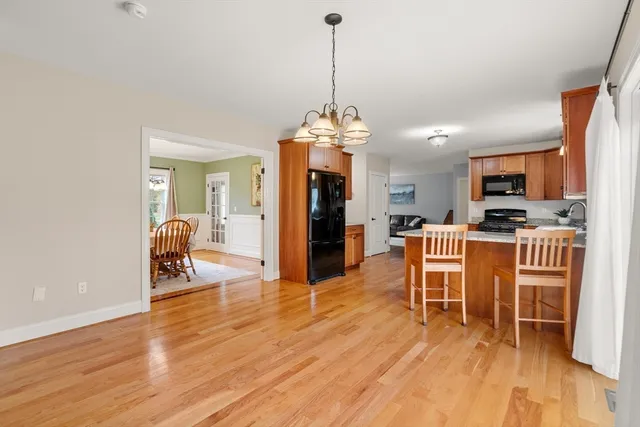 a dining room with furniture a chandelier and wooden floor