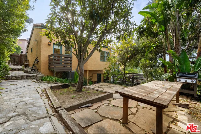 a view of house with backyard and furniture