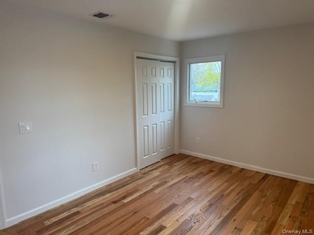 24 Moriches Road Lake Grove, NY 11755 - Photo 19 of 31 a view of an empty room with wooden floor and a window