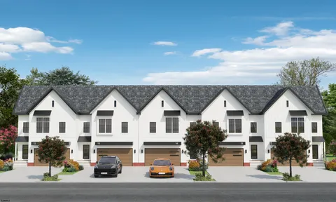 a view of a white house with large windows and a table
