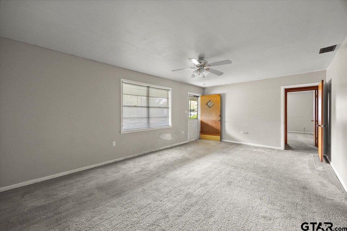 459 Main Street Rusk, TX 75785 - Photo 6 of 12 an empty room with chandelier fan and windows