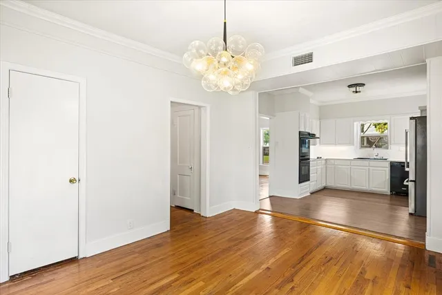 a view of a kitchen with refrigerator and wooden floor