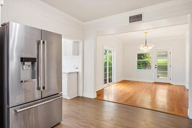 a view of an empty room with window and wooden floor