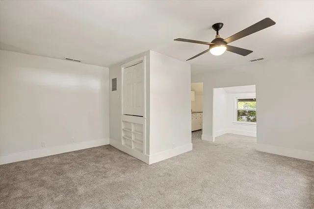 a view of a big room with closet and a ceiling fan