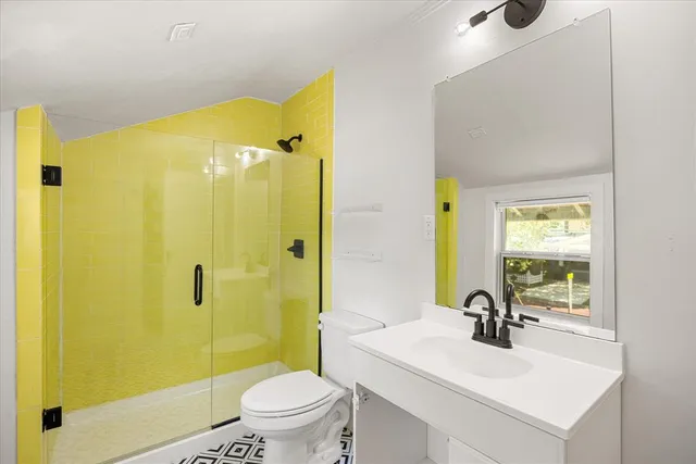 a bathroom with a sink a toilet and shower