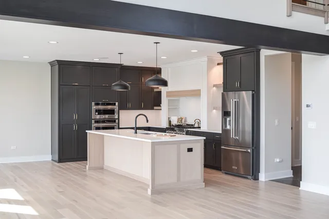 a kitchen with stainless steel appliances granite countertop a refrigerator a sink a stove and oven