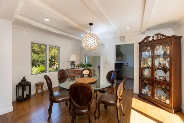 a dining room with furniture a chandelier and wooden floor