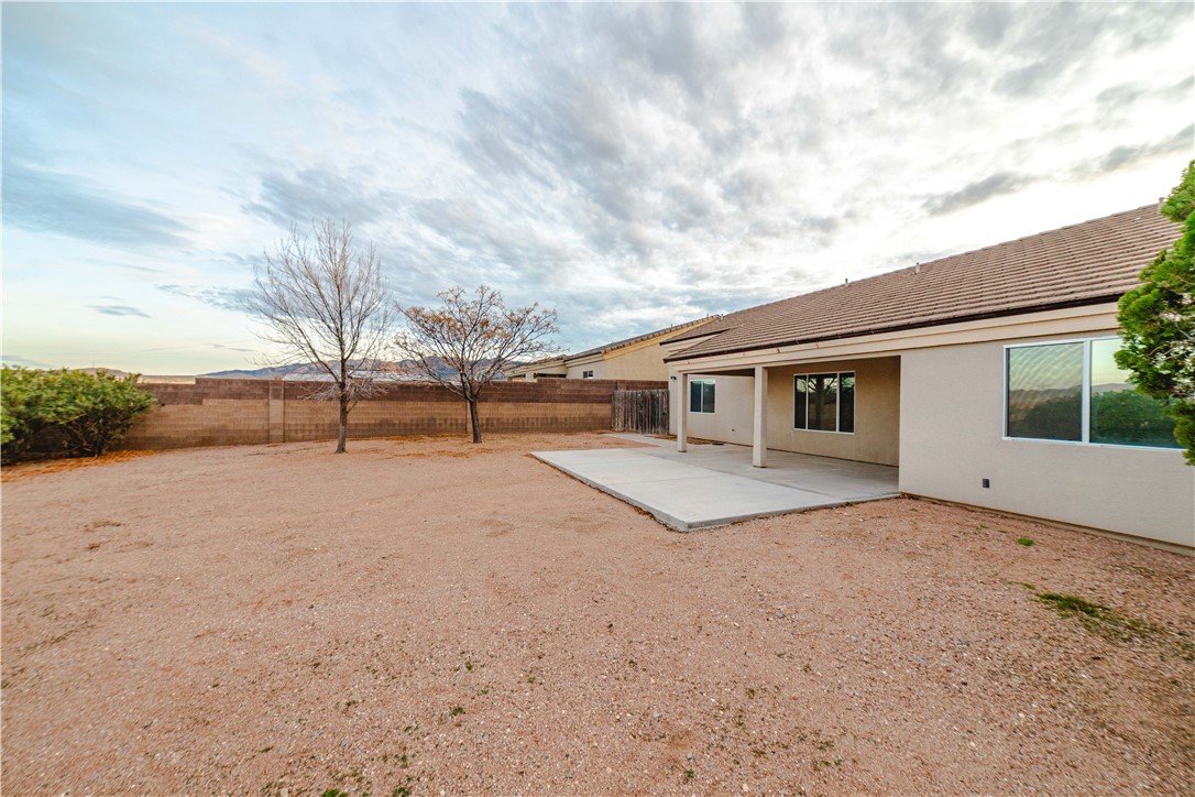3374 Roma Road Kingman, AZ 86401 - Photo 54 of 64 Rear view of house with stucco siding, a patio area, and a fenced backyard