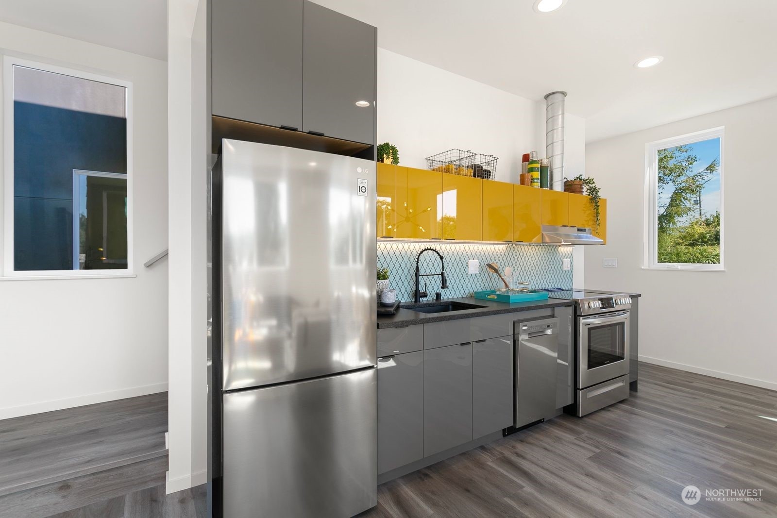 729 South Southern Street Seattle, WA 98108 - Photo 18 of 29 a kitchen with stainless steel appliances a refrigerator a sink a stove and white cabinets with wooden floor