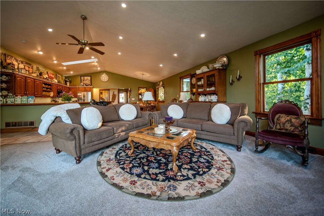 6549 Waterloo Road Atwater, OH 44201 - Photo 28 of 49 Living area featuring vaulted ceilings, recessed lighting, a ceiling fan, a large window with wood trim, and wood-finish cabinetry