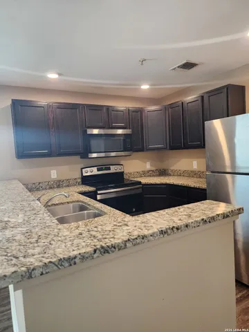 a kitchen with a refrigerator stove and sink