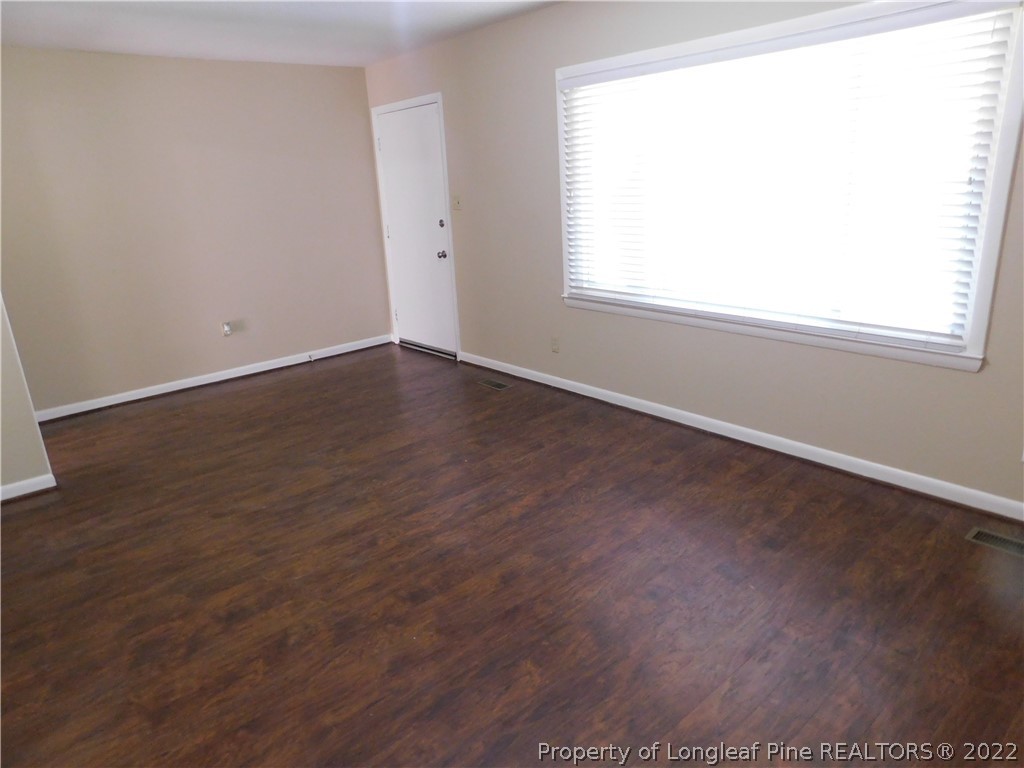 4451 Ruby Road Fayetteville, NC 28311 - Photo 3 of 14 an empty room with wooden floor and windows