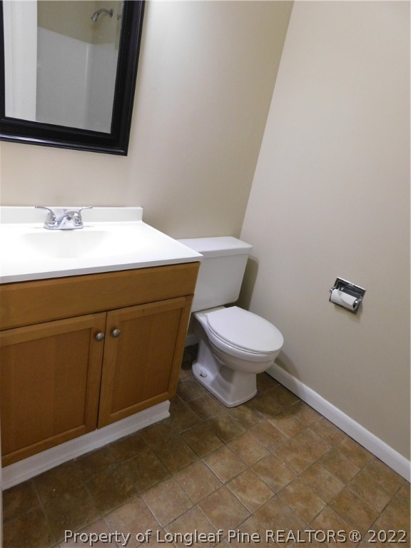 4451 Ruby Road Fayetteville, NC 28311 - Photo 9 of 14 a bathroom with a toilet a sink and mirror