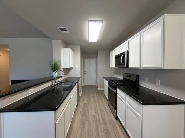 a kitchen with a sink a stove and cabinets