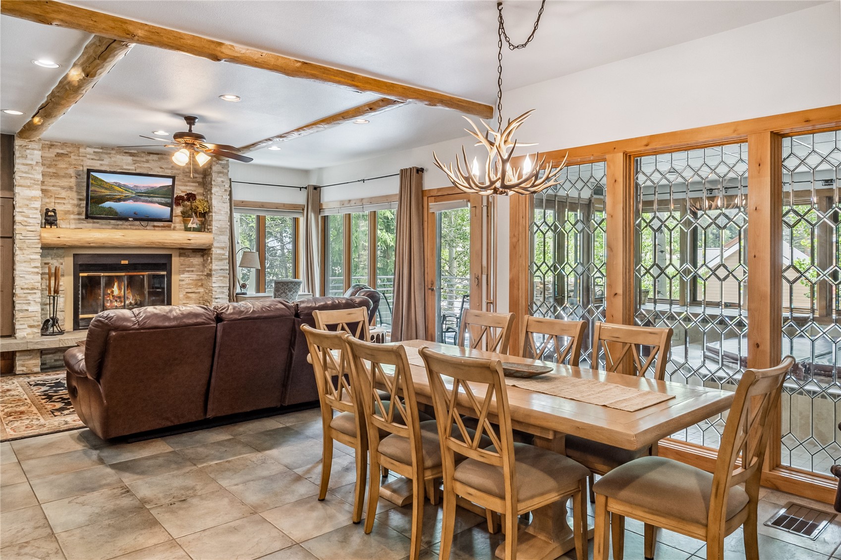 1201 West Keystone Road, Unit 2724 Keystone, CO 80435 - Photo 1 of 28 Dining space with beam ceiling, ceiling fan, notable chandelier, a fireplace, and light tile floors