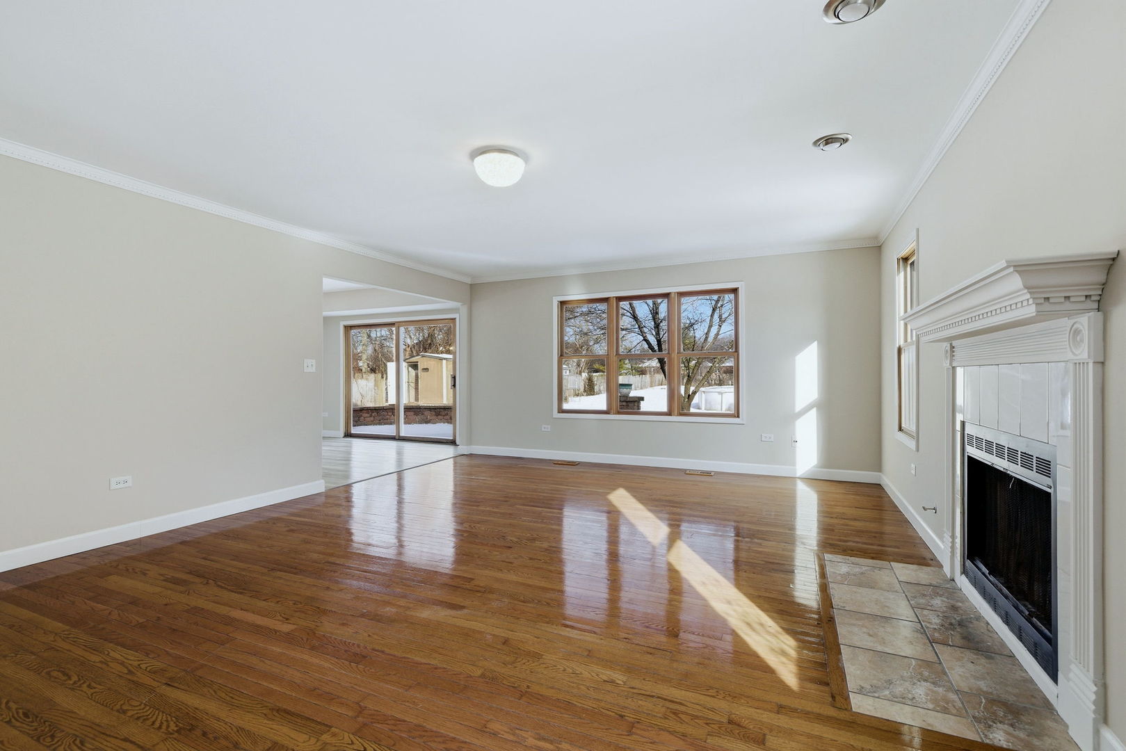 1305 Campbell Street Joliet, IL 60435 - Photo 11 of 34 an empty room with wooden floor fireplace and windows