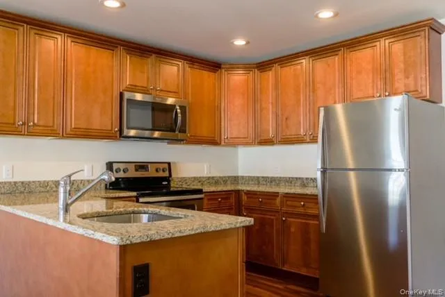 a kitchen with a refrigerator a microwave a sink and cabinets