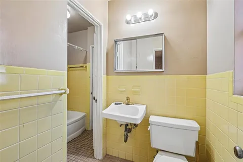 a bathroom with a sink a toilet and mirror