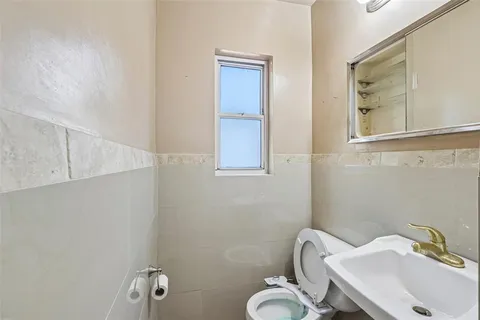 a bathroom with a sink mirror and toilet