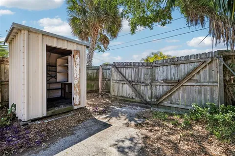 a view of a backyard with a plants and wooden fence
