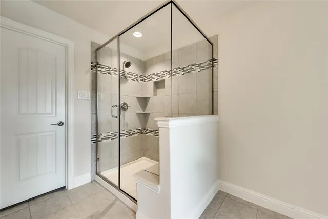 a bathroom with a glass shower door and a bathtub